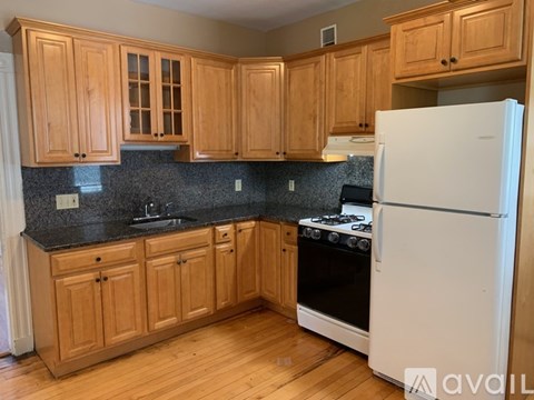 A kitchen with wooden cabinets and a white refrigerator.