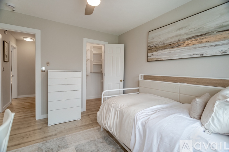 A bedroom with a large bed and a painting on the wall.