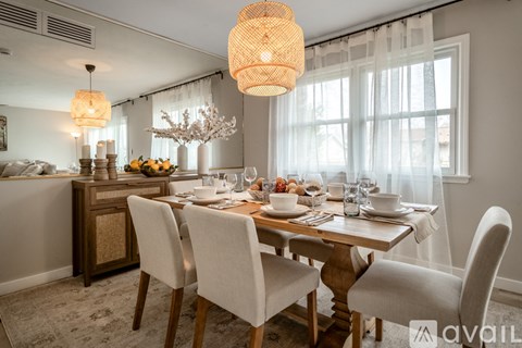 A dining room with a wooden table set for a meal.