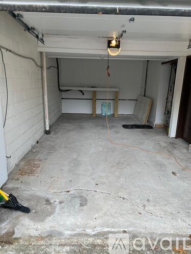 A garage with a white wall and a concrete floor.