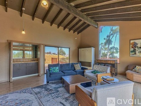 A living room with a blue couch and a rug.
