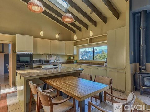 A kitchen with a table and chairs and a wood stove.