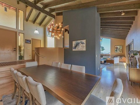 A dining room with a long table and chairs.