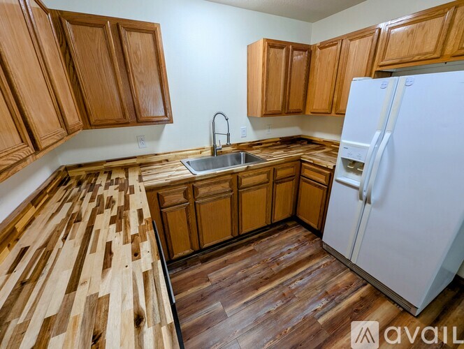 A kitchen with wooden floors and cabinets.