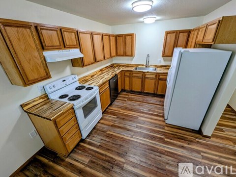 A kitchen with wooden cabinets and a white stove top oven.
