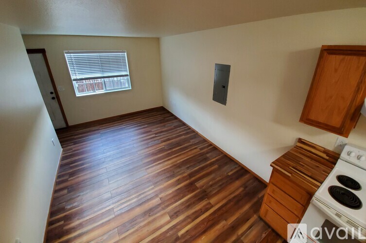 A kitchen with wooden floors and a white stove.