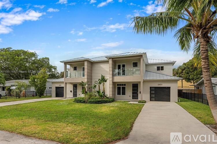 A modern house with a driveway and a palm tree in front.