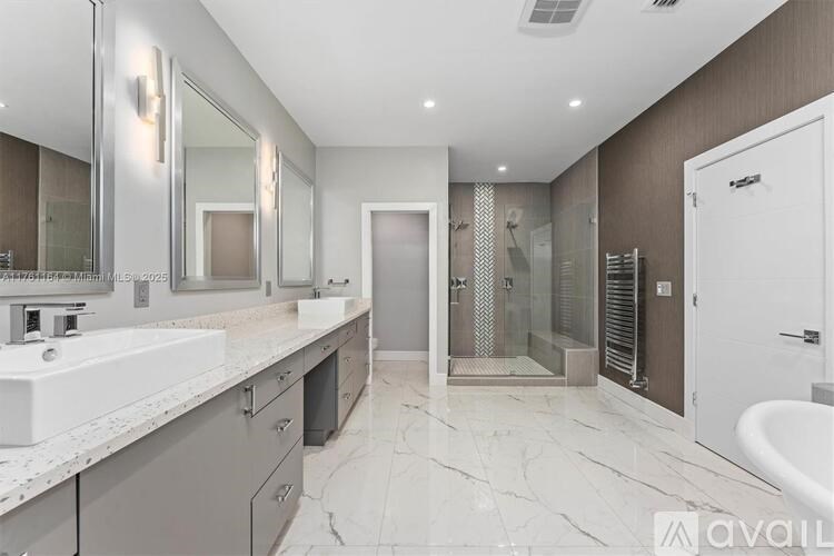 A spacious bathroom with marble flooring and a large mirror.