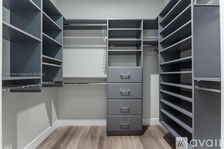 A room with grey shelving and drawers.
