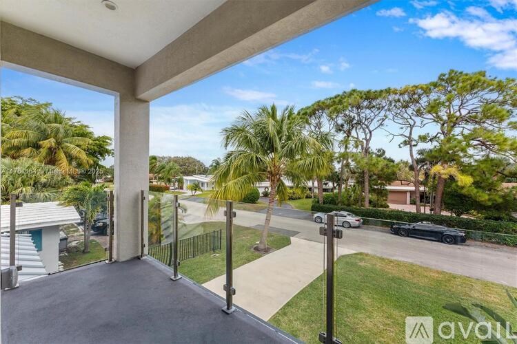 A balcony with a view of a street and trees.