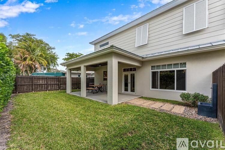 A house with a white exterior and a green lawn in front.