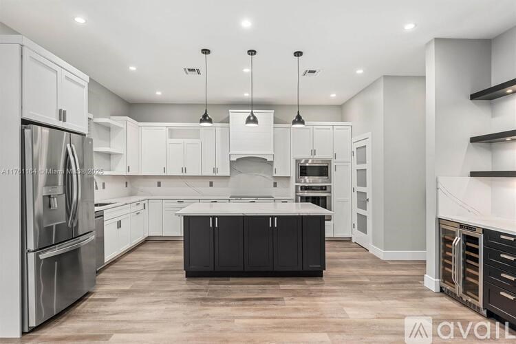 A modern kitchen with a center island and stainless steel appliances.