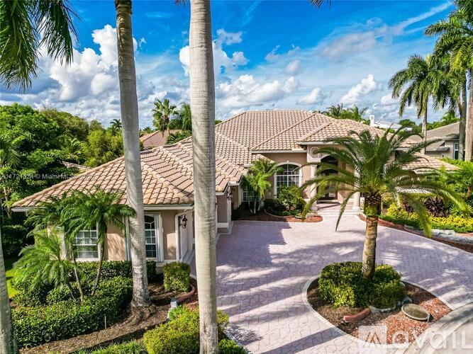 A house with a red tile roof surrounded by palm trees.