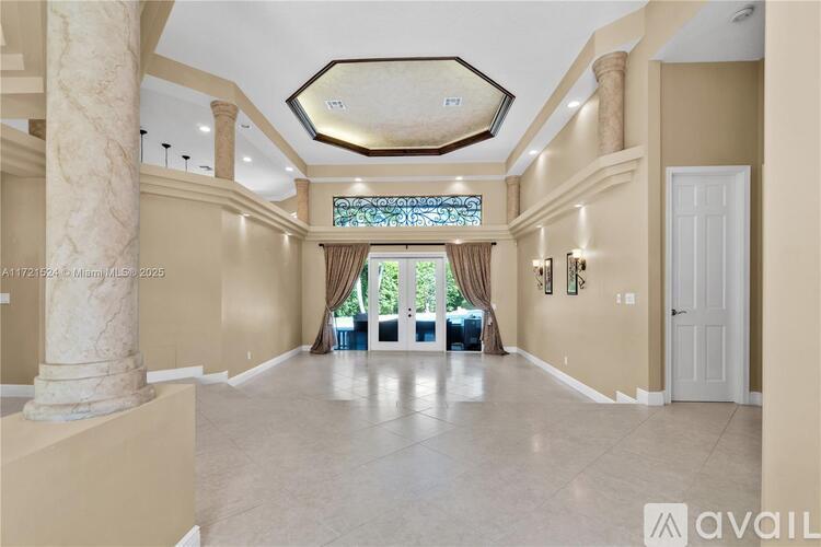 A spacious hallway with a stained glass window and a white door.