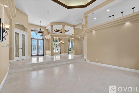 A spacious living room with a high ceiling and elegant lighting fixtures.