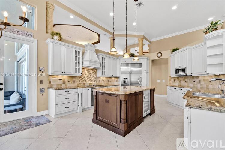 A kitchen with white cabinets and a wooden island.