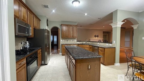 A kitchen with wooden cabinets and black countertops.