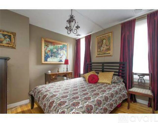 Bedroom with a bed, a chandelier, and a painting on the wall.