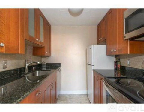 A kitchen with wooden cabinets and a white refrigerator.