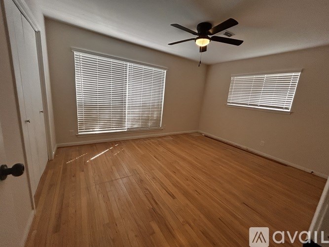 A room with wooden flooring and a ceiling fan.