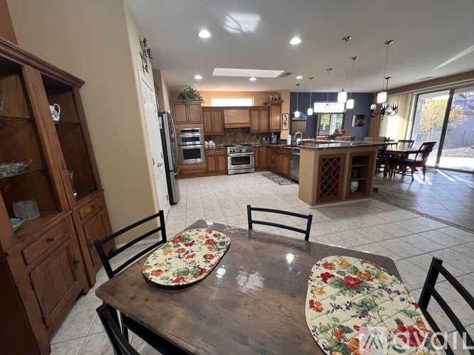 A kitchen with a table set for two with floral tablecloths.