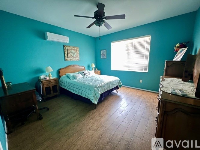 A bedroom with a bed, dresser, and ceiling fan.