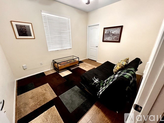 A living room with a black couch and a coffee table.