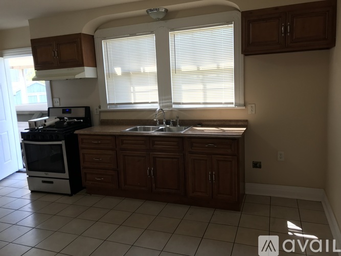 A kitchen with brown cabinets and a white stove top oven.