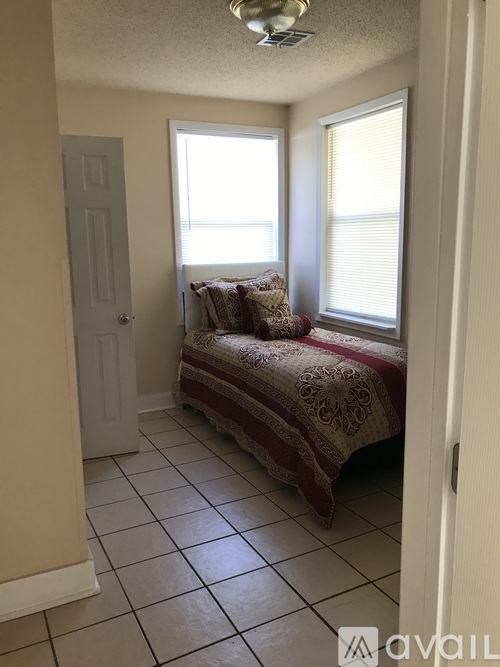 A bedroom with a bed and a window.