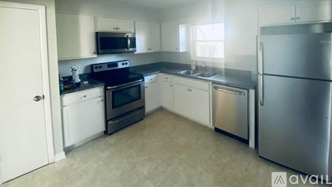 A kitchen with a refrigerator, oven, and microwave.