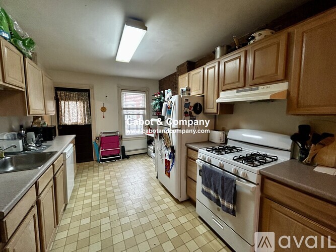 A kitchen with a white stove and wooden cabinets.