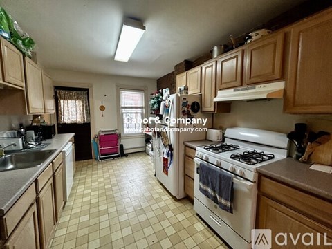 A kitchen with a white stove and wooden cabinets.
