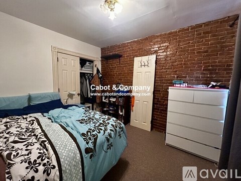 A bedroom with a bed, dresser, and closet.