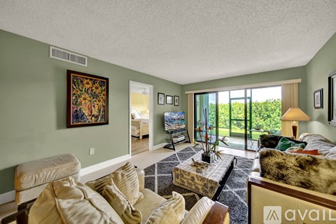 A living room with a couch, chair, and a painting on the wall.