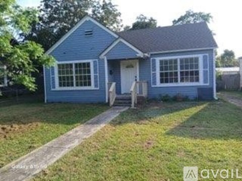 A small blue house with a white door and windows.