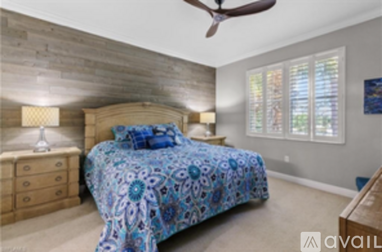 A bedroom with a bed, dresser, and ceiling fan.
