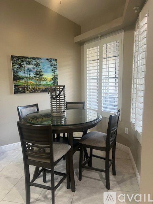 A dining room with a table and chairs.