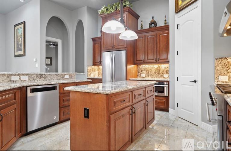 A kitchen with wooden cabinets and a granite countertop.