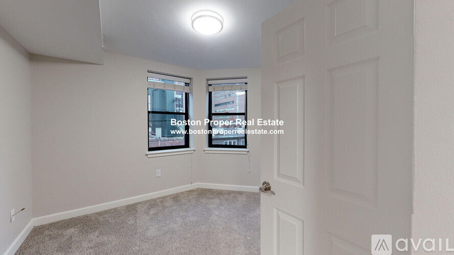 A room with a window showing a view of a building with the text "Boston Property Real Estate" on it.