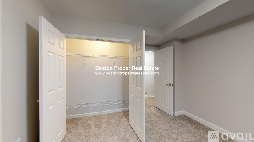 A bedroom with a carpeted floor and white walls.