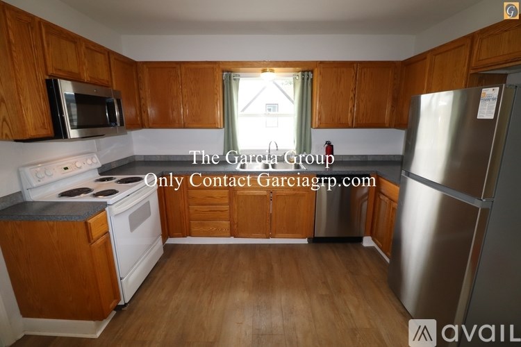 A kitchen with wooden cabinets and a stainless steel refrigerator.