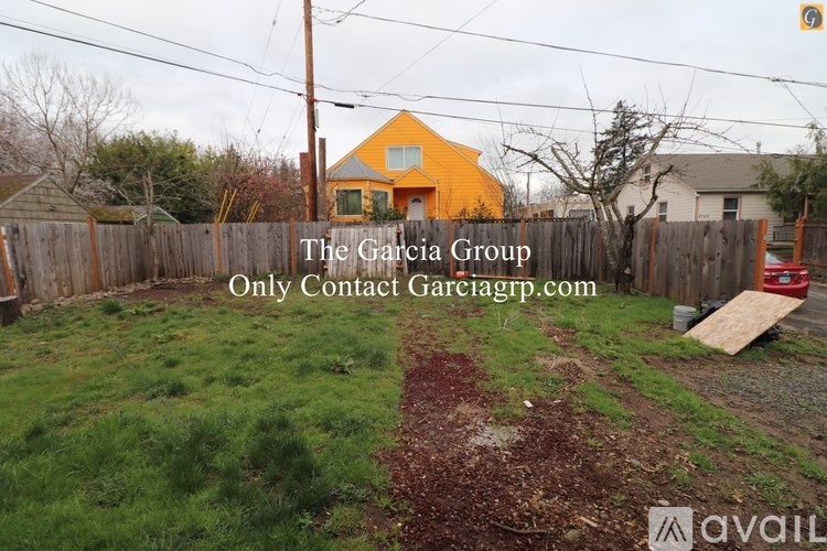 A yellow house is in the background of a grassy yard.