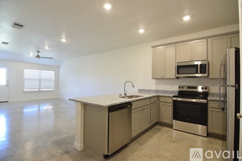 A kitchen with a white countertop and stainless steel appliances.