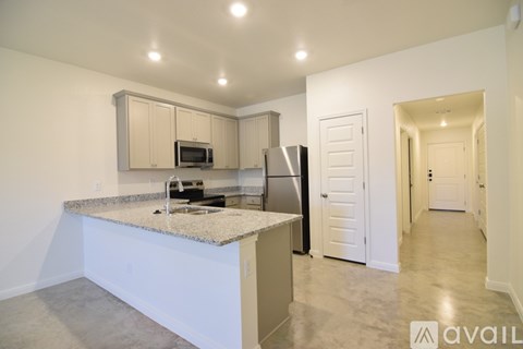 A kitchen with granite countertops and white cabinets.