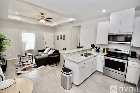A modern kitchen with white cabinets and stainless steel appliances.