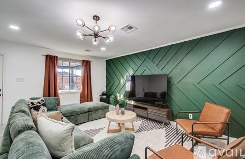 A living room with a green couch and a television.