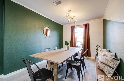 A dining room with a wooden table and chairs.