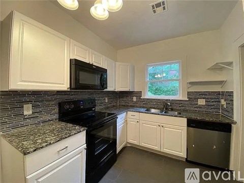 A kitchen with black appliances and granite countertops.