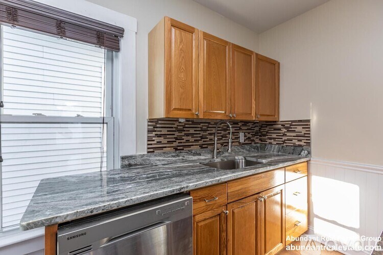 A kitchen with wooden cabinets and a granite countertop.