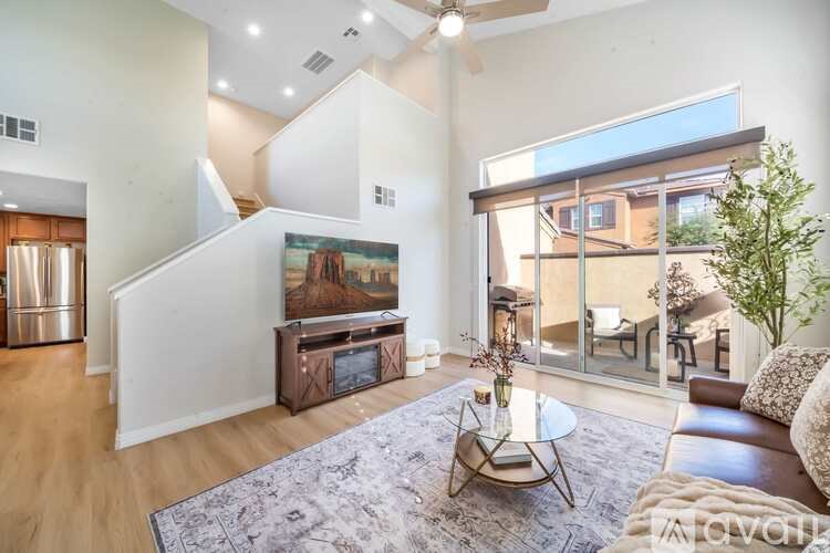 A living room with a brown leather couch and a coffee table in front of a painting.